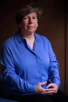 Portrait of Randi Weingarten, a prominent Jewish American figure and leader in education. She is pictured sitting confidently in a deep blue shirt, with her hands gently clasped in front of her. The background is softly blurred, focusing attention on her composed and thoughtful expression. This image highlights her role as an advocate for teachers and public education, emphasizing her influence and commitment to improving educational systems