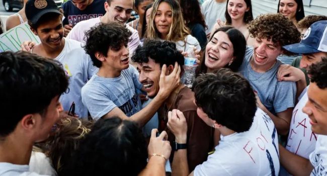 Marcelo Gomes da Silva, center, is embraced by friends outside his home after his release from ICE detention. Boston Globe / Contributor / Getty Images