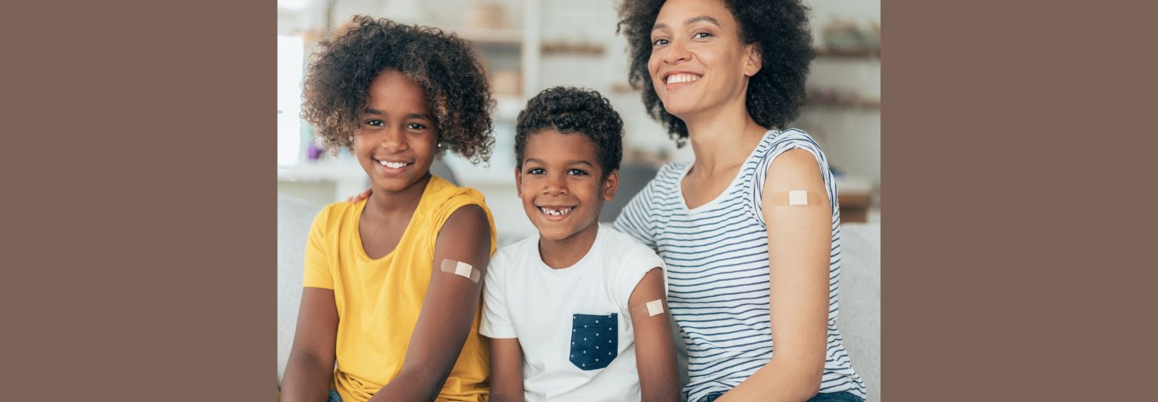 Smiling parent with two children, all showing bandages on their arms after vaccination—representing confidence in immunization, family health, and informed vaccine decision-making.