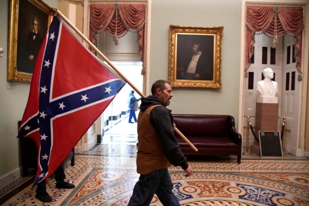 white privilege on display as a domestic terrorist and support of donald trump walks the halls of the capitol with a confederate flag